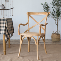 Chaise de restaurant à dossier croisé avec structure en bois et accoudoirs, siège rembourré en rotin