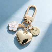 Porte-clés de luxe exquis en alliage en forme de cœur avec pendentif orné de jolies perles et motifs de fleurs de thé, et embellissements en lettres métalliques