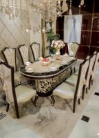 Table à manger ovale de luxe de style néoclassique européen, en bois massif sculpté, finition champagne argenté, avec chaises en cuir.