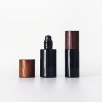 Nuevo frasco de vidrio redondo oscuro con tapa de abeto y dosificador, con bomba para loción, serigrafía y logotipo personalizado, para set cosmético y cuidado de la piel.