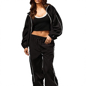 Chaqueta cortavientos negra personalizada al por mayor con logo, para mujer, con cremallera completa, cuello tipo embudo y ribetes en contraste, tela con ligeras arrugas. - Product Image 1
