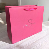 Sac en papier horizontal violet personnalisé avec logo en relief et poignées en ruban de la même couleur pour l'emballage de vêtements, de cosmétiques et de cadeaux