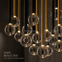Lustre en verre transparent à bulles suspendues avec pendentifs longs pour réceptions d'hôtel et halls de villas à double hauteur
