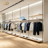 Portant à vêtements sur mesure en métal et bois, du sol au plafond, avec étagères et éclairage LED pour boutique de prêt-à-porter