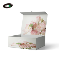 Boîte d'emballage rigide personnalisée pour t-shirt avec logo rose, gaufrage et pelliculage mat, en carton gris recyclable pour vêtements