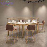 Aménagement intérieur sur mesure pour bijouterie, présentoirs et menuiseries personnalisés pour bijoux, vitrine en métal doré et verre pour boutique de détail