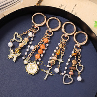 Nouveau porte-clés rond en alliage, breloque de sac en forme de croix, perles, papillon, cœur, très vendu