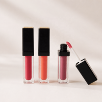 Gloss à lèvres liquide végétalien en tube rectangulaire transparent avec capuchon carré noir mat, applicateur floqué et plaque supérieure dorée, teintes rouge baie, vente en gros