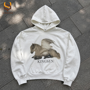 เสื้อฮู้ดดี้ผู้ชายแบบสั่งทำ OEM สีงาช้าง ผ้าคอตตอนหนา พิมพ์ลายม้าเทวดาด้วยเทคนิค DTG ประดับหมุดสีเงิน สไตล์สตรีทแวร์ Y2K ทรงบ็อกซี่ - Product Image 1