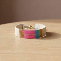 Pulsera de algodón tejida a mano Sstringz, detalles de cuentas en color blanco marfil, rosa intenso, azul turquesa y dorado, ajustable.