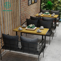 Ensemble de meubles de restaurant, café et bar moderne, tables à manger en bois et canapés avec sièges en tissu, design moderne et simple