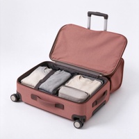 Valise à roulettes souple rouge rouille avec poche avant à rabat à boucle, sangles de compression et poignée télescopique