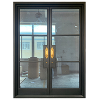 Porte d'entrée élégante en acier, fabriquée à la main en France, avec double vitrage trempé, poignées dorées pour une isolation acoustique, ouverture manuelle