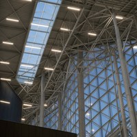 Centre d'exposition en structure acier industrielle avec murs intérieurs en verre spacieux et un look contemporain