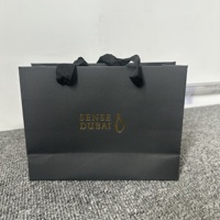 Sac de shopping en papier kraft recyclé noir mat de luxe personnalisé avec logo en feuille d'or et poignée en corde de coton pour l'emballage de vêtements
