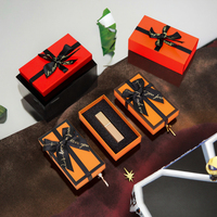 Boîte cadeau en carton magnétique orange avec logo personnalisé, doublée d'éponge, structure rigide écologique, ruban à nœud, laminage mat