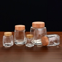 50ml 100ml 180ml 280ml 360ml 500ml 750ml Stoples Madu Kaca Persegi dengan LOGO Kustom, Stoples Kaca Persegi untuk Makanan dengan Tutup Bambu Tutup Logam