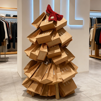 Sacs en papier kraft empilés de manière créative en forme de sapin de Noël, ajoutant une touche festive à l'affichage des magasins de vêtements