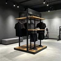 Isla de Exhibición de Malla Metálica Negra de 360 Grados con Estantes de Madera y Barras Colgantes para Tienda de Ropa Deportiva