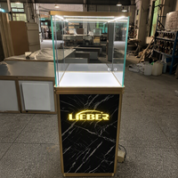 Vitrine carrée moderne en verre HonTay avec socle anthracite, panneau lumineux de marque et finition argentée pour présentation de bijoux en magasin ou showroom, robuste