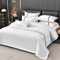 Ensemble de draps de lit de style hôtelier en coton blanc avec bordure à rayures jacquard grises, broderie personnalisée du logo de la marque, housse de couette