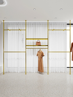 Présentoir pour vêtements de la boutique personnalisée Présentoir mural pour vêtements pour magasins de vêtements Présentoir pour vêtements doré pour magasin de vêtements
