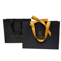 Sacs en papier en carton imprimés personnalisés de marque de luxe au détail pour les poignées de vêtements d'affaires avec vos propres logos sac cadeau à provisions