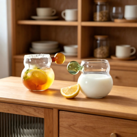 Bouteille en verre monocouche de luxe de haute qualité avec design minimaliste, poignée sphérique en forme de gourde, surface transparente estampillée or
