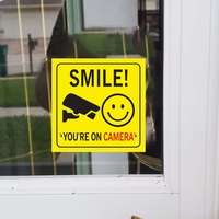 Panneau en acrylique « Souriez, vous êtes en caméra » – Décoration de fenêtre, avis de surveillance, maison, entreprise, commerce – Style simple et amusant, résistant aux UV