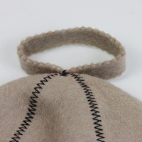 Un chapeau de sauna en pure laine beige qui équilibre la vapeur avec un emblème Yin Yang qui profite de chaque côté de la chaleur