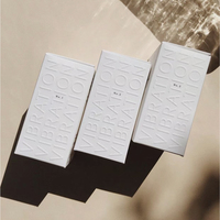 Ensemble d'articles de toilette de luxe pour hôtel : brosse à dents, shampoing, savon, emballage en boîte de carton texturé avec logo en relief
