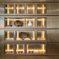 Vitrine de présentation de lunettes de luxe en or champagne, niche murale rétroéclairée, îlot tour rond, mobilier pour magasin de lunettes et boutique d'optique