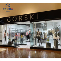 Porte-vêtements moderne pour boutique, en fer noir, sur pied, avec étagères de rangement ouvertes