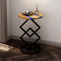 Table d'appoint ronde en bois d'olivier naturel et résine époxy avec base géométrique en métal pour le salon et la chambre à coucher.
