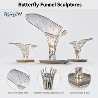 Grande sculpture trompette inclinée en acier inoxydable poli miroir, avec dôme ovale ajouré en maille organique, éclairage LED, sur pieds multiples, pour repère de place publique, personnalisable