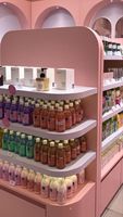 Meubles de magasin de cosmétiques en bois personnalisés modernes et tendance, présentoir à parfums rose sur mesure pour l'agencement de magasin de maquillage