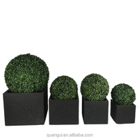 Sphères de topiaires artificielles en buis, style minimaliste moderne, dans des pots carrés noirs pour la décoration intérieure.