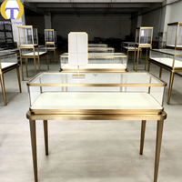Vitrine à bijoux en verre sur mesure de luxe, cadre en métal doré, éclairage LED, écologique, robuste, personnalisable pour les articles haut de gamme