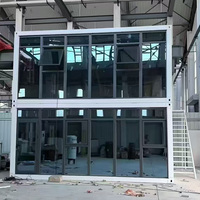 Conteneur Détachable à Double Étage avec Façade Modulaire en Verre, Terrasse Ouverte et Escalier Extérieur en Métal pour Utilisation en Camping en Milieu Rural ou sur Colline