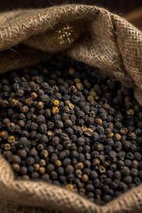 Granos de pimienta negra en cuchara de madera sobre fondo negro para condimentar en la cocina - Product Image 4