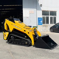 Derette V1000 Mini Skid Steer Loader dengan Berbagai Fungsi Lampiran: Bucket, Grapple, Mulcher, Mesin Diesel Kubota, dan Sistem Crawler.