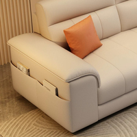 Canapé 3 places en cuir technique avec surpiqûres en V, accoudoirs incurvés et poches latérales de rangement, idéal pour salon moderne