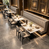 Table à manger en marbre blanc avec base en X, chaises rembourrées en cuir beige, banquette, mobilier de restaurant personnalisable, fournisseur en gros