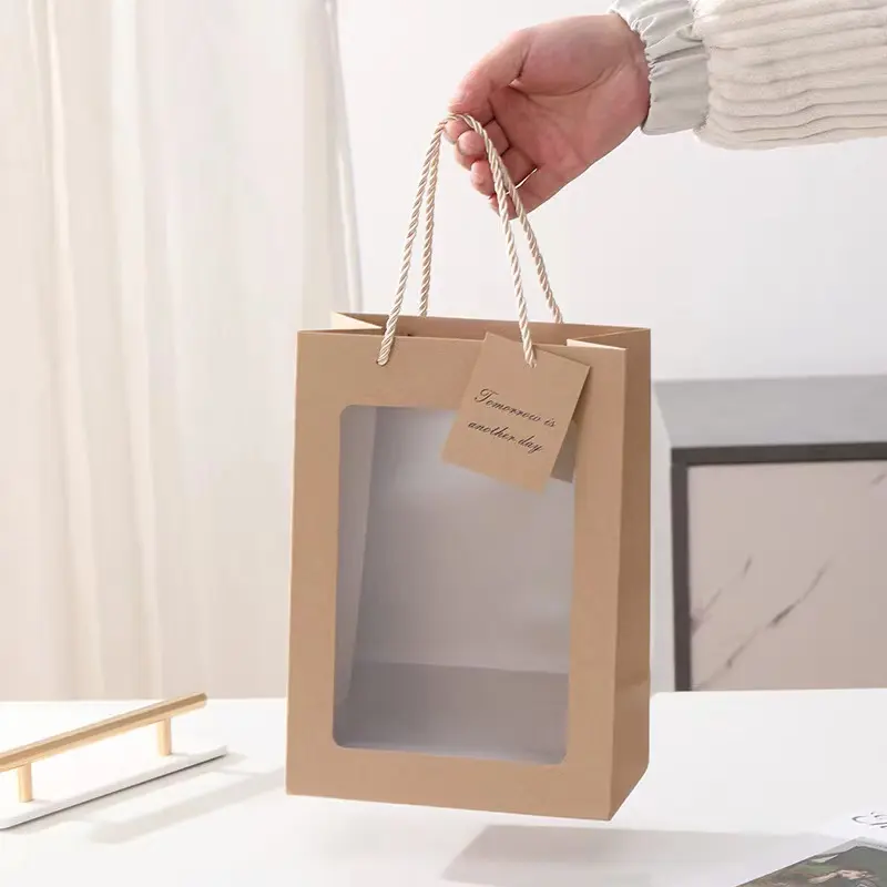 Vente en gros de sacs en papier artisanaux avec logo personnalisé sacs recyclables en papier pour l'emballage des cadeaux avec fenêtre en PVC