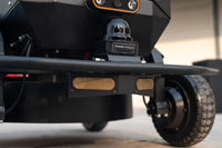 Robot autonome à quatre roues noir avec caméra frontale stationné sur un vaste champ de gazon vert en plein air