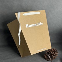 Sac cadeau en papier kraft blanc trapézoïdal personnalisé en gros avec poignée en ruban et logo estampé à chaud or ou argent