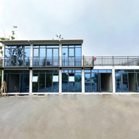 Bâtiment de bureau modulaire préfabriqué en conteneurs, 5 unités combinées, 2 étages, avec murs entièrement vitrés et grande terrasse balcon.