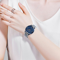 Montre-bracelet pour femme avec cadran scintillant, index en cristal, aiguilles en forme de feuille et bracelet en maille bicolore