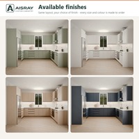 Meuble de cuisine minimaliste en PVC en forme de U avec portes en panneaux vert sauge, boîtes en MDF et poignées intégrées