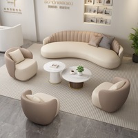 Chaise de canapé en cuir incurvé de luxe léger avec table à thé pour le salon de beauté dans le hall de l'hôtel